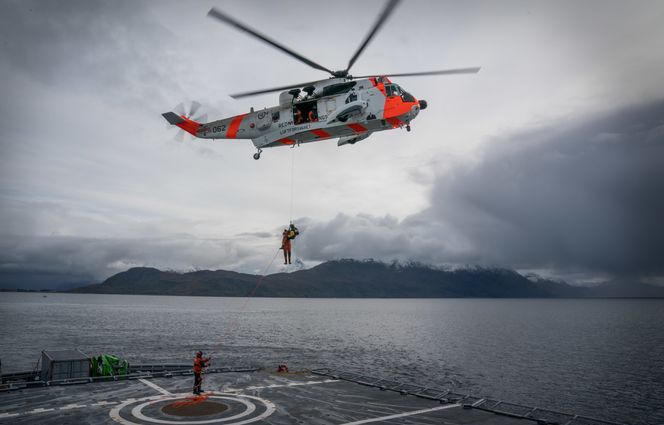 Et Sea King redningshelikopter samarbeider her med dronen for å redde en person (dukke) som har falt ombord. Foto: Eirik Helland Urke