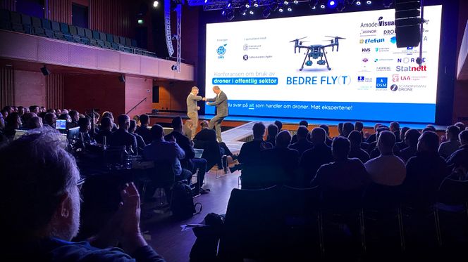 Ketil Solvik-Olsen er spesialrådgiver i UAS Norway og leder konferansen om bruk av droner i offentlig sektor. Her albuehilser han på en foredragsholderne. Foto:  Eirik Helland Urke