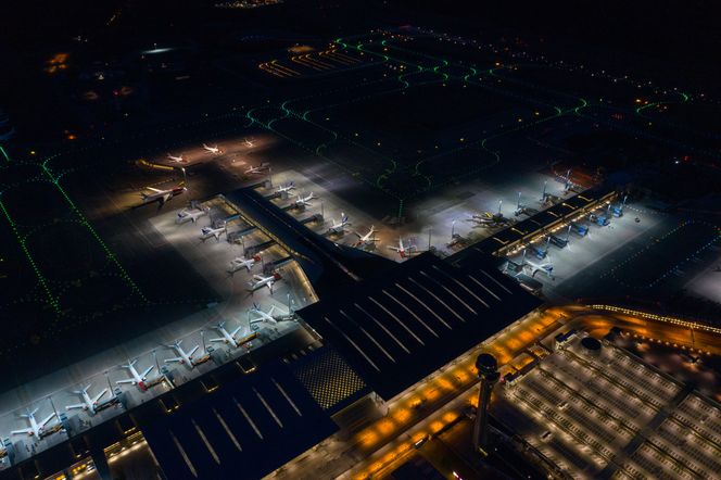 Parkerte fly står på rekke og rad ved gatene på Oslo Lufthavn. Tårnet og de tomme parkeringsplassene skimtes til høyre i bildet. Foto: UAS Norway/Hans Torgersen