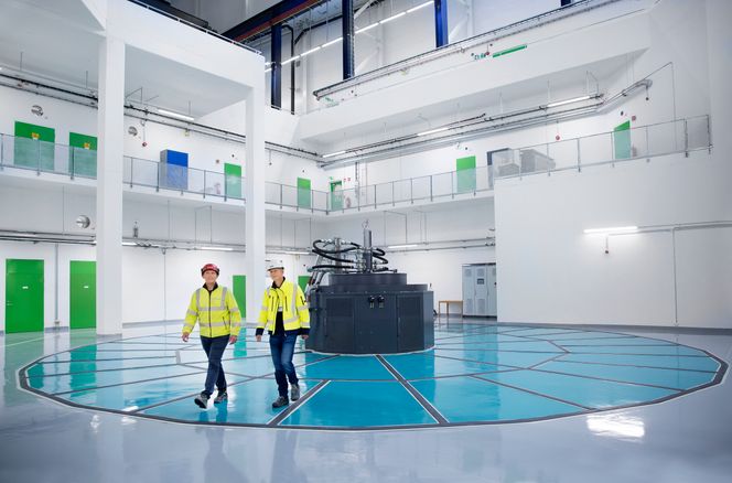 Byggeleder Martin Sørby fra A.L. Høyer (til venstre) og Fridjar Molle, prosjektleder hos Hafslund Eco, på toppen av generatoren. De blå platene, som gir en god indikasjon på dimensjonene, kan fjernes for vedlikehold. Foto: Sverre Chr. Jarild
