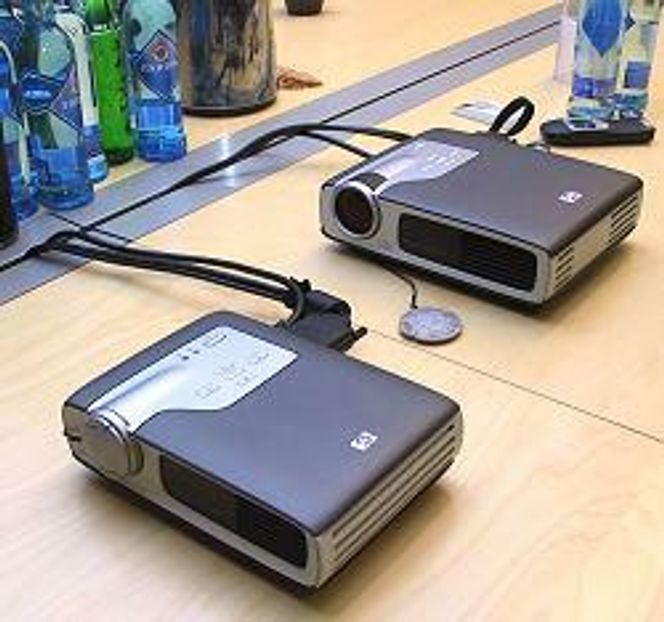 HP sb21 (foran) kan dekkes under et A5-ark, og veier knapt et kilogram. Den leverer 800 ANSI lumen og gjengir bilder i SVGA-oppløsning. Utgangene er allsidige: VGA (standard skjerm), DVI (digital video), S-VHS og Composite. Prisen er 22.448 kroner eks mva. HP sb31 er litt større og veier 600 gram mer. Det øker oppløsningen til XGA og lysstyrken til 1200 ANSI lumen. I motsetning til hos lillebror, er det både høyttaler og zoomlinse. Det øker prisen med 11.000 kroner. Utgangene er de samme.
