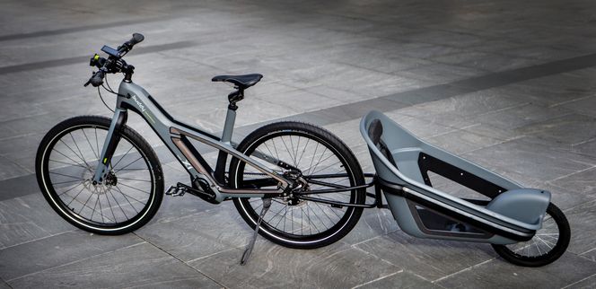 En ethjulsvogn hvor barnet er snudd motsatt vei, er en løsning for å øke sikkerheten ved å snu barnets hode bort fra biler. Tanken er å koble på et kamera for å gi barnet ansiktskontakt med syklisten. Tilvalgsutstyr blir mulig å kjøpe etter hvert. Foto:  Eker Design