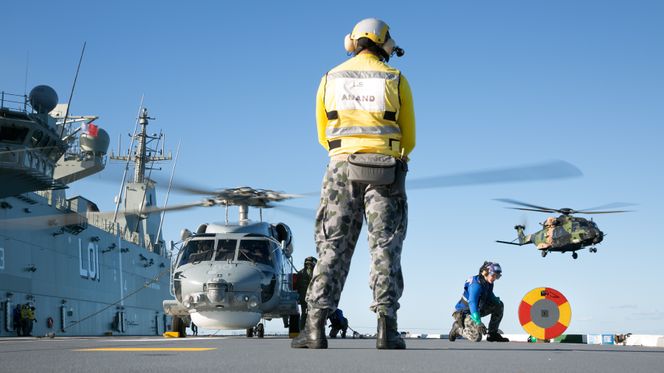 MRH-90 Taipan (t.h) og et S-70B-2 Seahawk, som er i ferd med å motta drivstoff, om bord på amfibiekrigsskipet HMAS Adelaide. Foto:  LSIS Peter Thompson