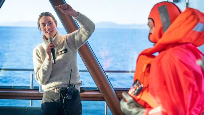 Guiden Bettina Fredriksdóttir forteller hvordan overlevingsdraktene skal tas på. Foto:  Eirik Helland Urke