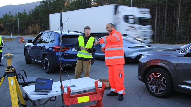 Fv. seniorforsker Anders Rødningsby i Forsvarets Forskningsinstitutt og Vegvesenets testansvarlige Tomas Levin. Vogntoget i bakgrunnen er en tilfeldig forbipasserende på E8, og har ingen tilknytning til saken. Foto: Bjørn Olav Amundsen