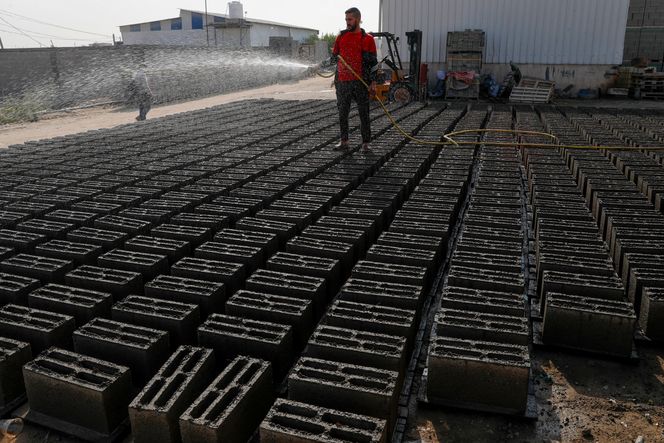 Antar al-Katatni sprayer vann på betongblokker lagd av resirkulerte ruiner. Foto: Adel Hana/AP/NTB