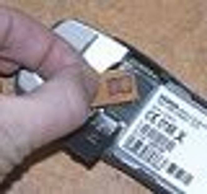Simkort fra Netcom settes inn i mobil.