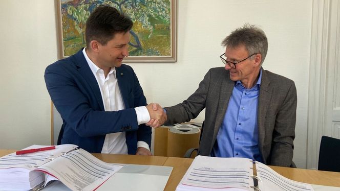 Bertil Horvli, kommunalsjef infrastruktur og samferdsel i Drammen kommune og Mathias Fabich fra PNC Norge med et godt håndtrykk etter signering av avtale om bygging av ny bybru. Foto: Drammen kommune