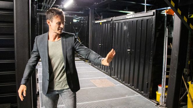Prosjektleder for Audi charging hub, Ewald Kreml viser frem innsiden av ladestasjonen. Den er modulær og krever ikke grunnarbeider. Nødvendig infrastruktur er installert i containere som skyves på plass under bygging.  Foto:  Marius Valle