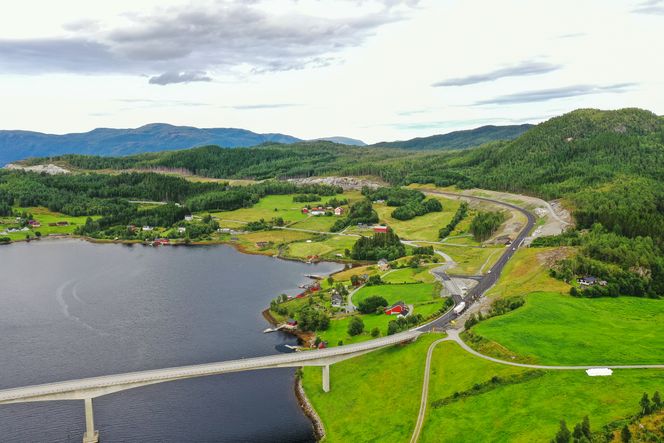 Gamleveien går nærmest fjorden, mens nyveien går oppe i lia. Her sett fra Leirvika. Foto: Statens vegvesen