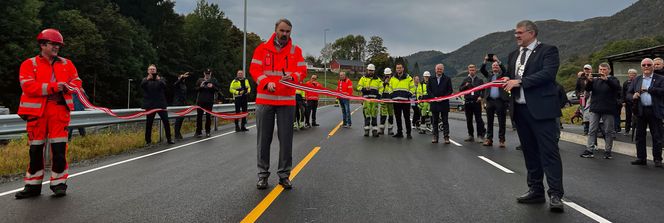 Divisjonsdirektør Bjørn Laksforsmo klipper snora, og veistrekningen er offisielt åpnet. Tv. byggeleder Roberto Balzer, og th. Vindafjord-ordfører Ole Johan Vierdal. Foto:  Statens vegvesen