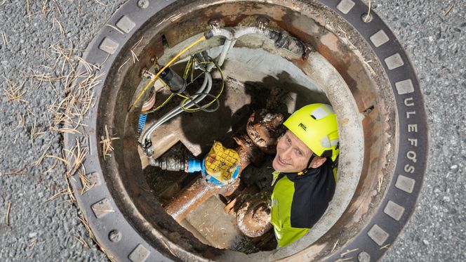 Johannes Devik nede i en kum på Ullern i Oslo for å inspisere hydrofonen som lytter etter lekkasjer. Foto: TUM Studio