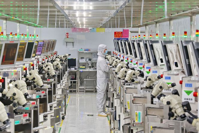 En mann på jobb i en databrikkefabrikk i Nantong i Jiangsu-provinsen øst i Kina. Nye amerikanske sanksjoner gjør det vanskeligere for Kina å kjøpe høyteknologisk vestlig utstyr til bruk i denne industrien. Bildet er tatt i september 2022. Foto: AP / NTB
