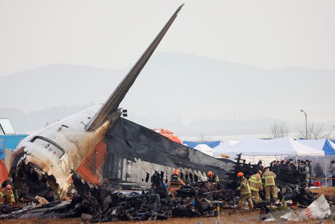 Folk arbeider på stedet der et fly kjørte av rullebanen og krasjet på Muan internasjonale lufthavn i Muan i Sør-Korea. Foto:  Kim Soo-hyeon/Reuters/NTB