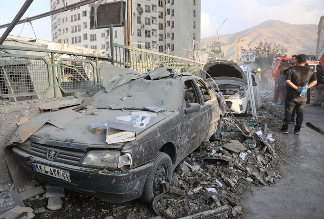 Folk samles ved skadde kjøretøy etter israelske angrep, i Teheran. Foto: Majid Asgaripour/Wana/Reuters/NTB