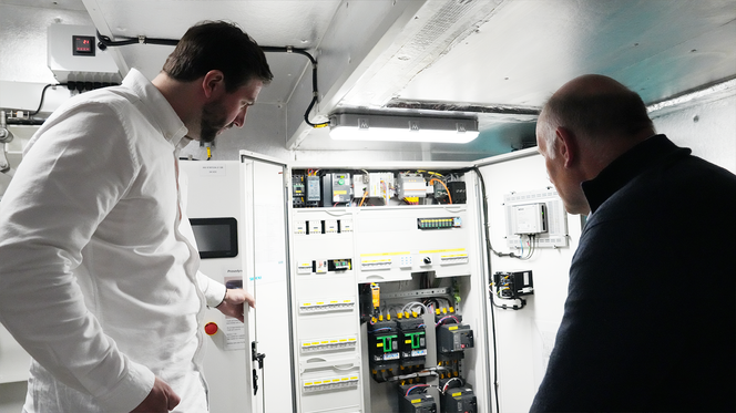 T.v.: Espen Larsen-Hakkebo viser elektrotavla som er «hjernen» i MS Brisen: De to kompakte ComPact NSX effektbryterne nede i bildet sørger for både sikkerhet. Med integrert Micrologic 5E-vern kan de både måle og kommunisere strømdata. Foto: Stefania Nilsen / Schneider Electric