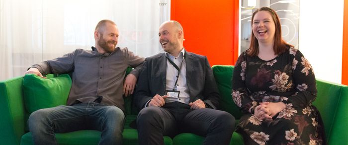 Morten (utvikler), Eivind (IT-direktør) og Heidi i DMZ-loungen i kontorlandskapet. 