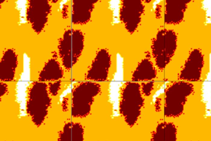 Figur 2. Barinks resultater fra en simulering som viser optimalisert materialkomposisjon (tre materialer) hvor ønsket anisotropisk termisk ledningsevne er oppnådd. Simuleringsresultatene viser områder med høy konduktivitet (hvit), lav konduktivitet (oransje) og ikke ledende materialer og tomrom (rødt). Mange enhetsceller er satt ved siden av hverandre.