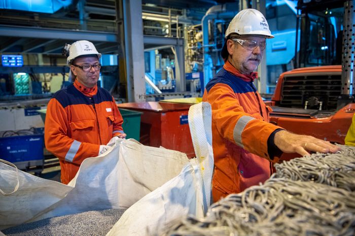 Høyanger, og Hydros øvrige aluminiumverk i Norge, utvikler nå metoder for å anvende brukt aluminium direkte i produksjonen av ny aluminium. Fabrikksjef Arne-Martin Kjærland og Helge Vadheim viser frem brukte høyspentledninger som er klare for resirkulering. <i>Foto:  Halvor Molland</i>
