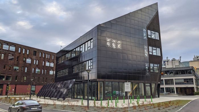 – ZEB-laboratoriet i Trondheim er kledd i svarte bygningsintegrerte solceller på alle fasader og på tak, som er gunstig for energiproduksjonen. I tillegg ble det benyttet mange ulike størrelser og former på panelene for å utnytte alt areal og komme i mål med energimålet, forteller Anne Marte. <i>Foto:  Solcellespesialisten</i>