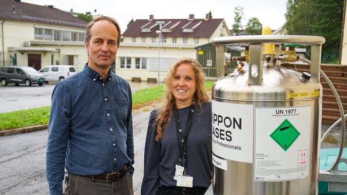 Cato Wendel og Arnhild Ruud ved IFE. I gassbeholderen er det nedkjølt, flytende nitrogen som benyttes i radiokjemiske analyser. Foto: TUM Studio