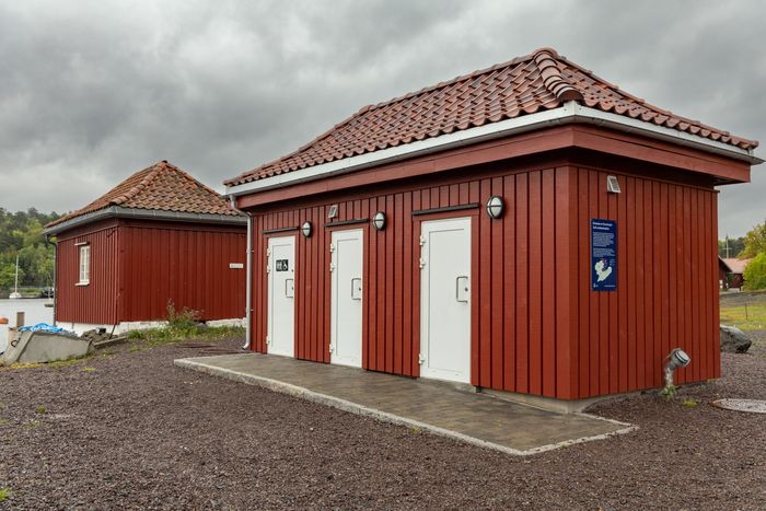 Ny avløpspumpestasjon med publikumstoalett på Hovedøya. Legg merke til hvordan bygget matcher det gamle huset ved siden av. <i>Foto:  TUM Studio</i>