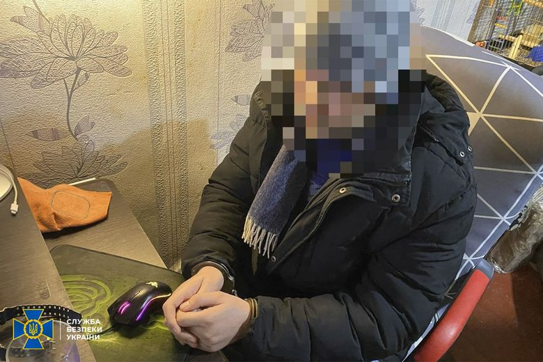 Den ukrainske hackeren som har blitt påført håndjern. I bakgrunnen ser man det som trolig er et fuglebur.  <i>Foto:  Sluzhba bezpeky Ukrayiny</i>