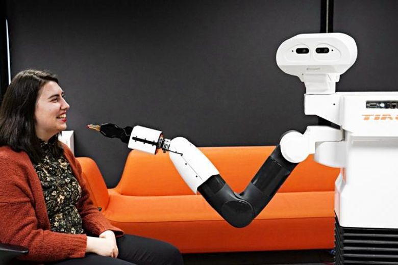 For at interaksjonen med roboter skal være så god som mulig er det viktig å forske. Derfor skal forskerne be robotene gjøre mange ulike oppgaver og se hvordan brukerne opplever dem. Her demonstrerer van Otterdijk at roboten TiaGo tar på henne leppestift. <i>Foto:  Elina Melteig/UiO</i>