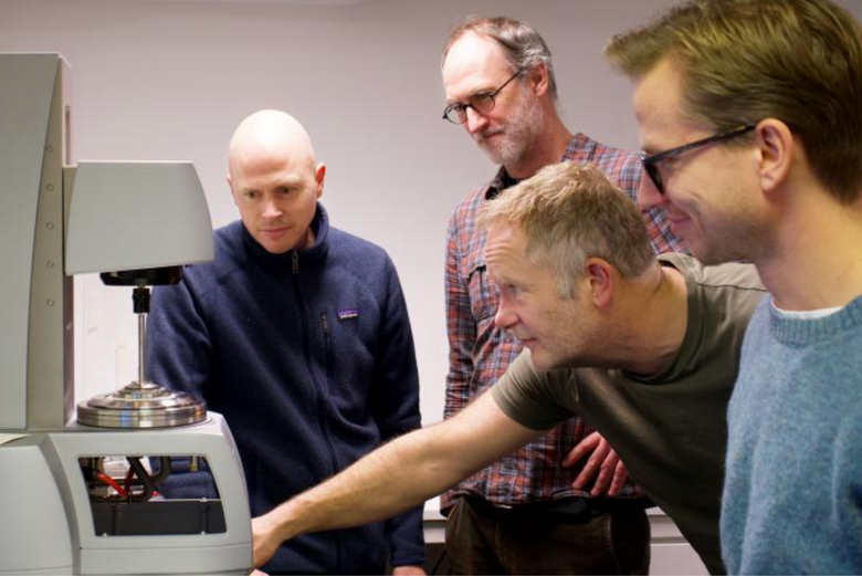 Andreas Carlson (t.v.), Atle Jensen, Eirik Strøm Lillebø og Torstein Sæter foran et rheometer som måler egenskaper ved lutefisk. <i>Foto:  Elina Melteig/UiO</i>