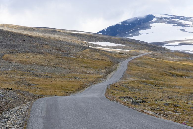 Takket være permafrosten bukter den bratte veien til Juvasshytta seg opp og ned. Det gjør det ikke enklere at asfalten er mørk. <i>Foto:  Yngve Vogt/Apollon</i>