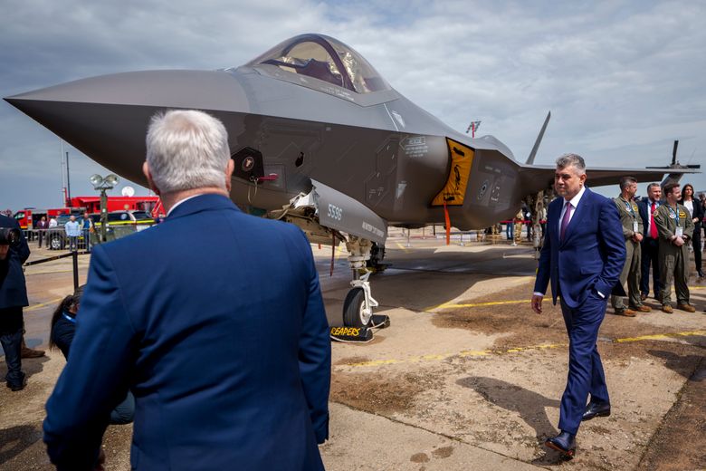 Romanias statsminister Marcel Ciolacu ser på et amerikansk kampfly av typen F35 under en våpenmesse i Bucuresti i mai i fjor. En rekke europeiske land, blant dem Norge, har kjøpt slike fly fra USA. <i>Foto:  AP/NTB</i>