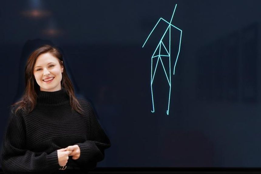 Benedikte Wallace ved siden av en realistisk dans av en kunstig intelligens. Foto: Elina Melteig/UiO
