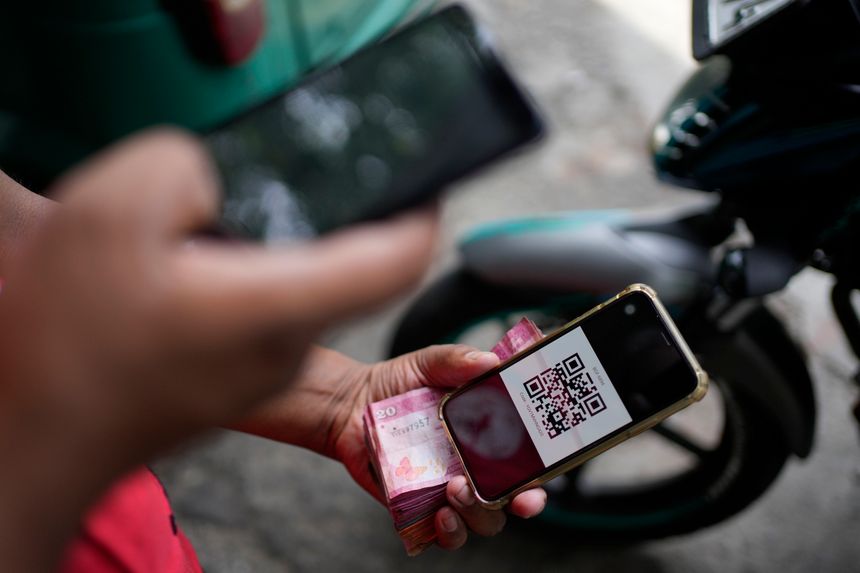 De kjente svarte og hvite strekene fyller 50 i disse dager, men nå tar snart den mønstrede firkanten QR-koden over for strekkodene. Foto: Eranga Jayawardena/AP/NTB