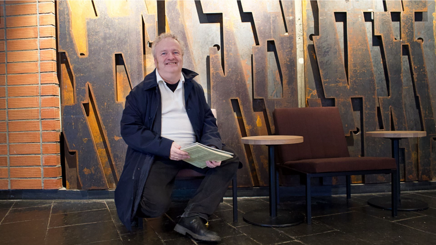 Wolfgang Plagge i foajeen på Norges Musikkhøgskole. I bakgrunnen ser du en del av kunstverket «Kontrapunkt» som er inspirert av Bachs «Die Kunst der Fuge» av Paul Brandts. Foto: Elina Melteig/UiO