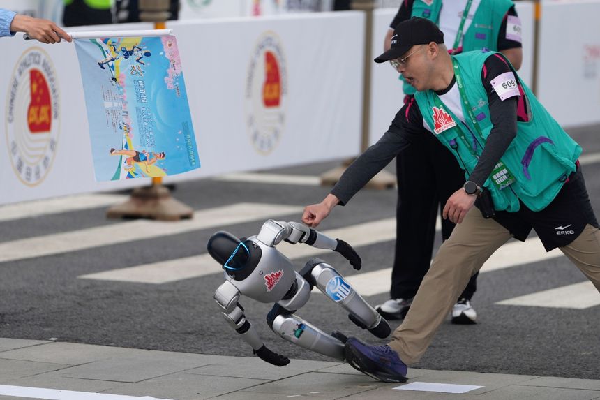 En robot mistet kontrollen på starten av halvmaratonløpet lørdag. Foto: Ng Han Guan/AP/NTB