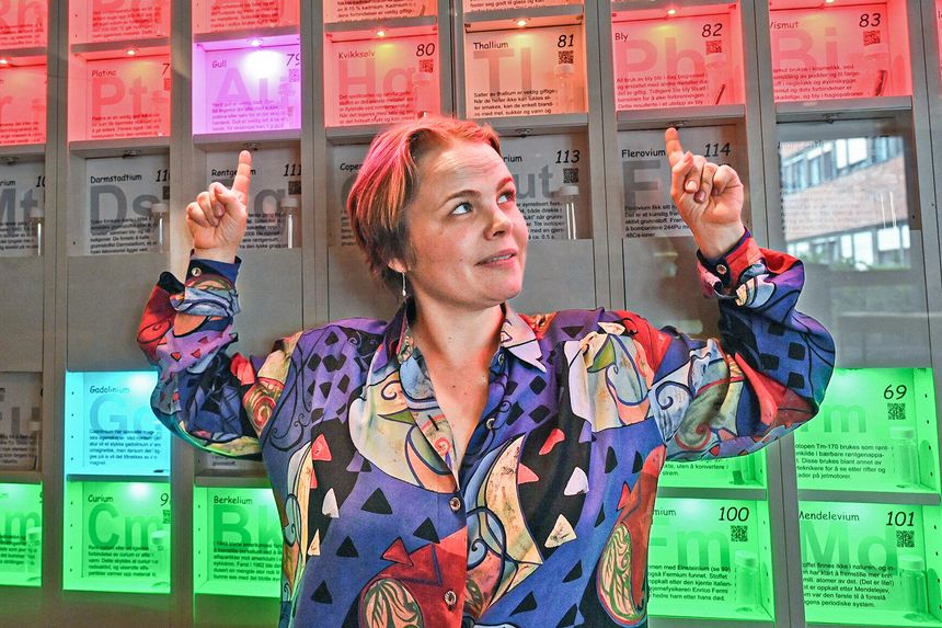 Bly (Pb) med atomnummer 82 mister noen ganger tre protoner i kjernen og blir til gull (Au) med atomnummer 79. Ida Storehaug peker ut grunnstoffene i det periodiske system. Foto:  Hilde Lynnebakken/UiO