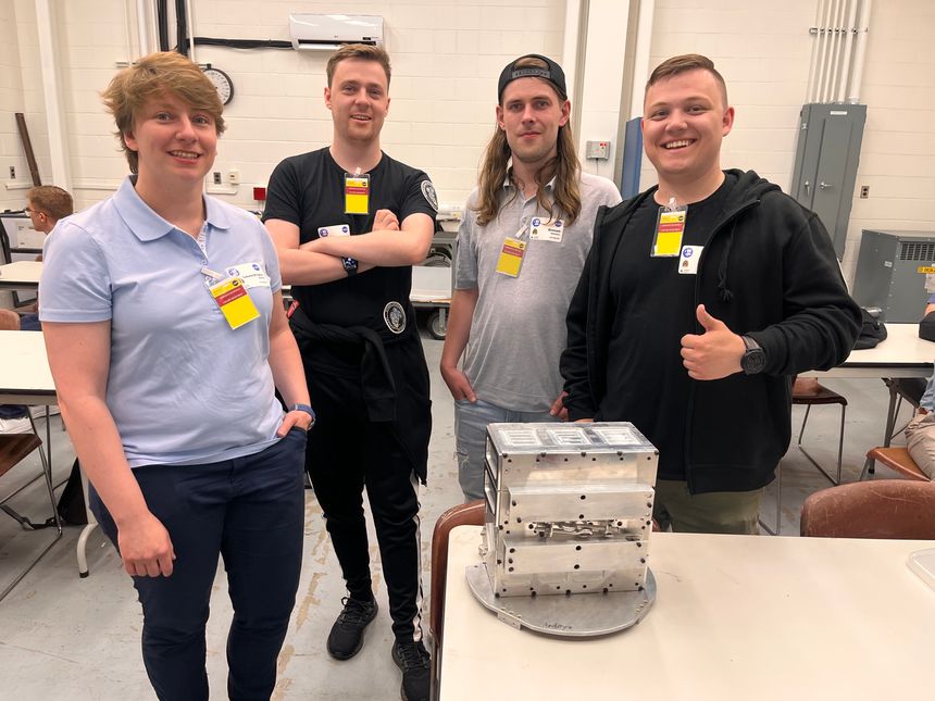 Laura-Kristin Scholtz, Askar Storbakk, Simon Tøllefsen og Chris Vebjørn Jensen på Nasa Wallops Flight Facility med CubeSat-Eject-podden som kaster ut satellittene fra raketten. Foto: UiT