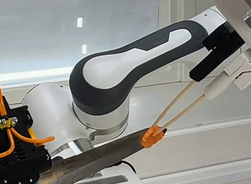 Det er finmotorikk på sitt beste når robotarmen fjerner laksebiten fra kniven. Foto:  Sintef