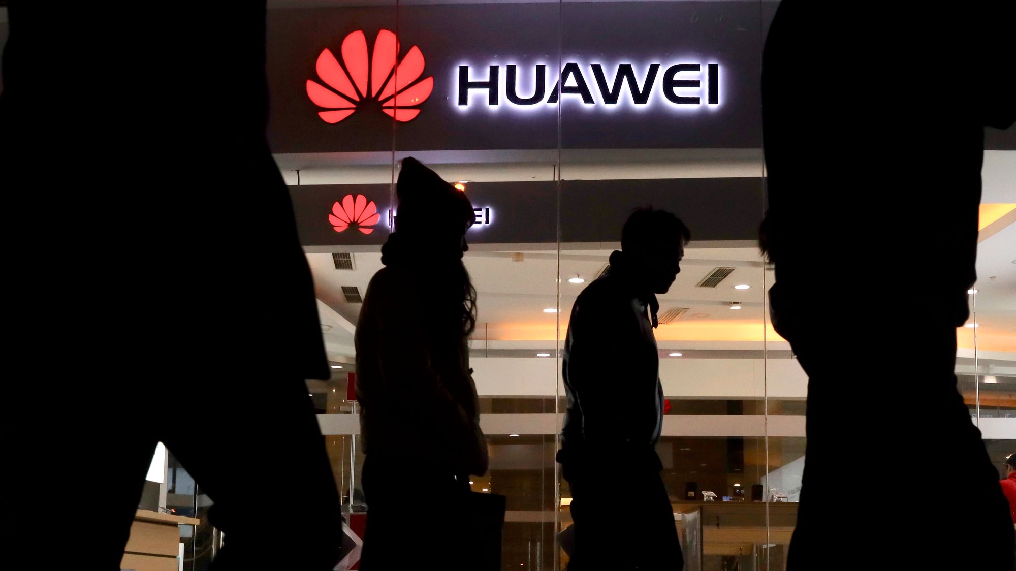 Pedestrians walk past a Huawei retail shop in Beijing Thursday, Dec. 6, 2018. China on Thursday demanded Canada release a Huawei Technologies executive who was arrested in a case that adds to technology tensions with Washington and threatens to complicate trade talks. (AP Photo/Ng Han Guan)