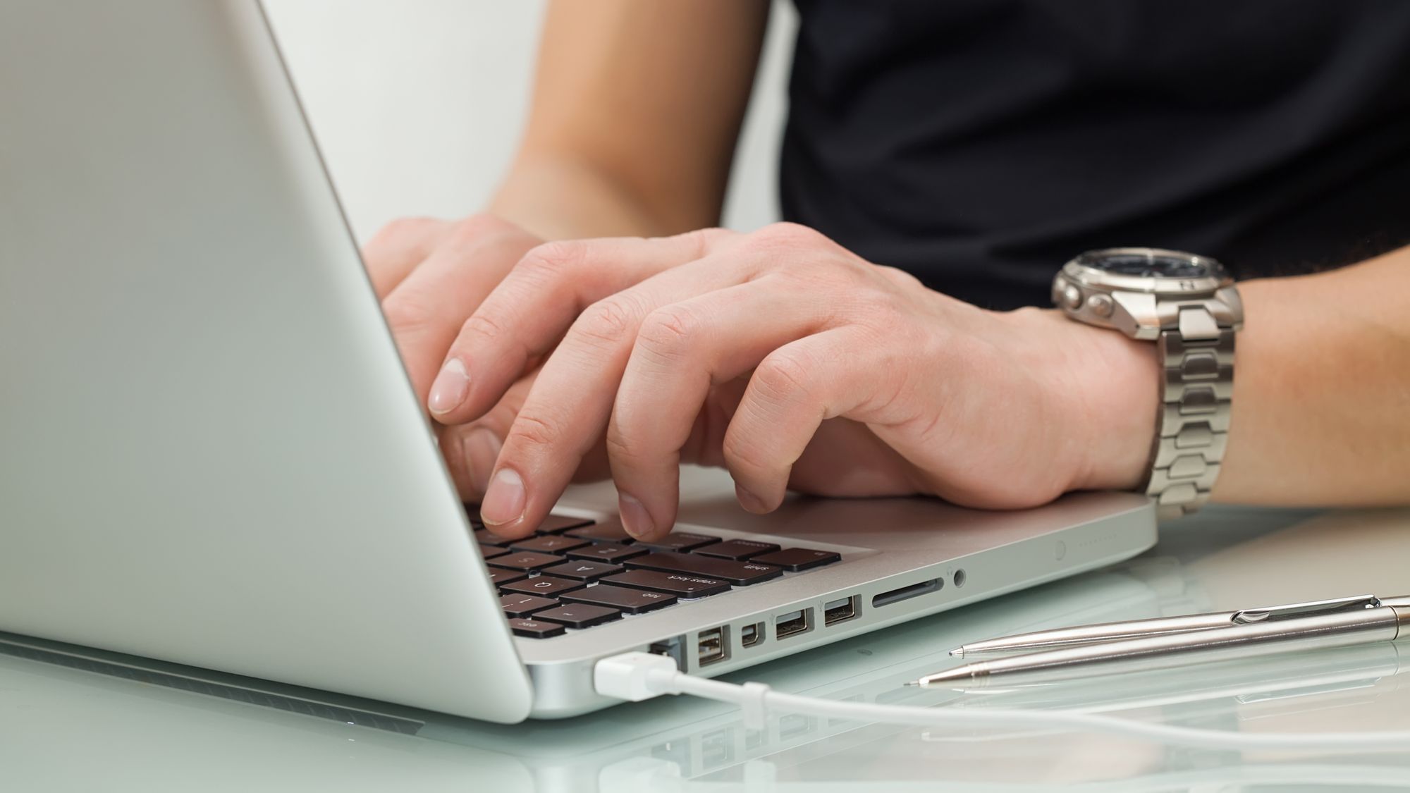 Businessman typing on a notebook (shallow DOF, hand in focus)