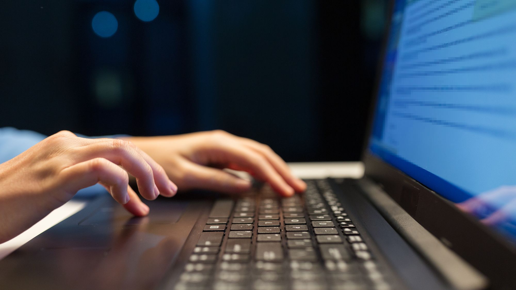 business, education and technology concept - close up of female hands with laptop typing at night