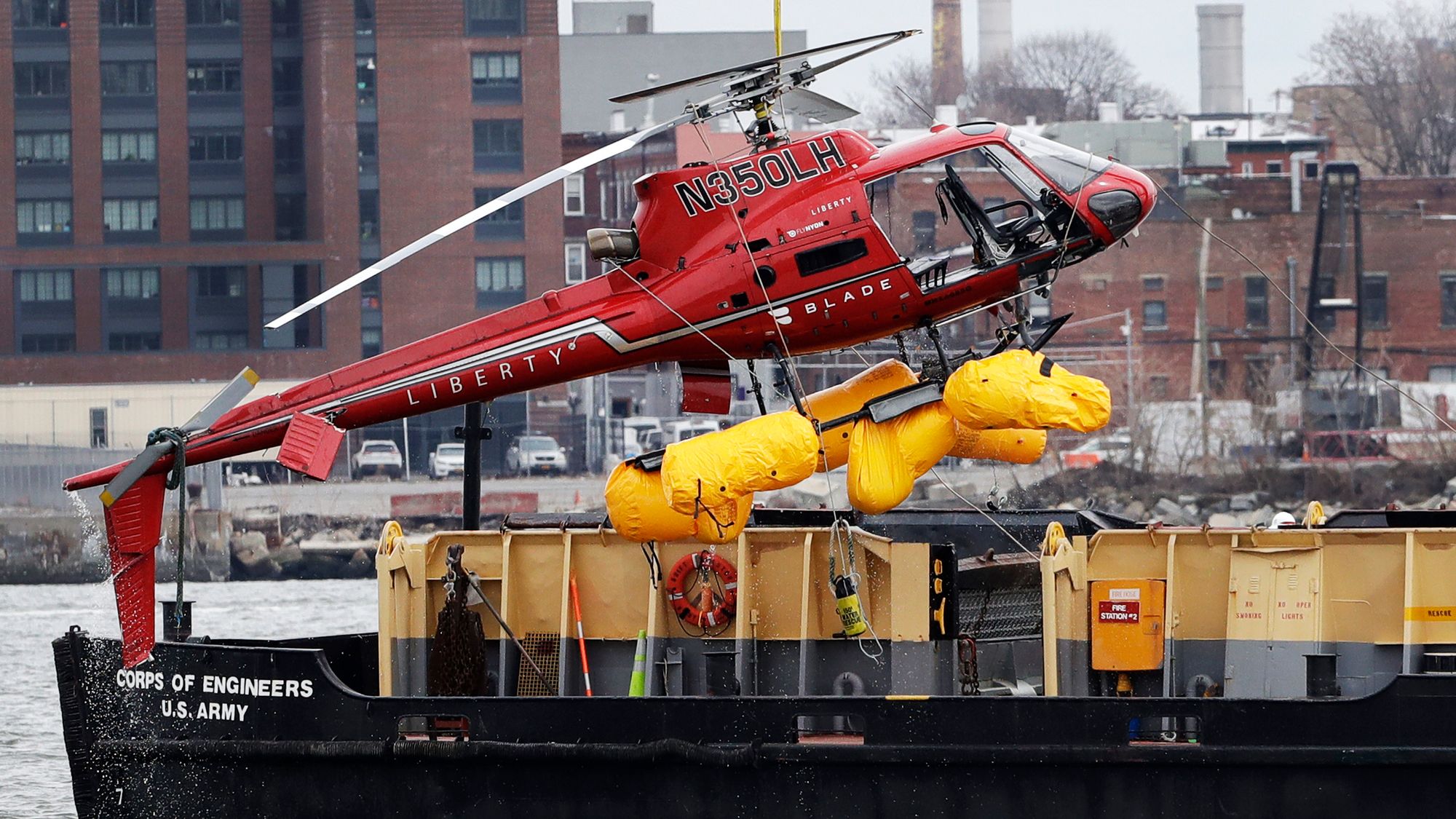 Ulykkeshelikopteret blir heiset opp på en pram dagen etter ulykken på East River i New York.