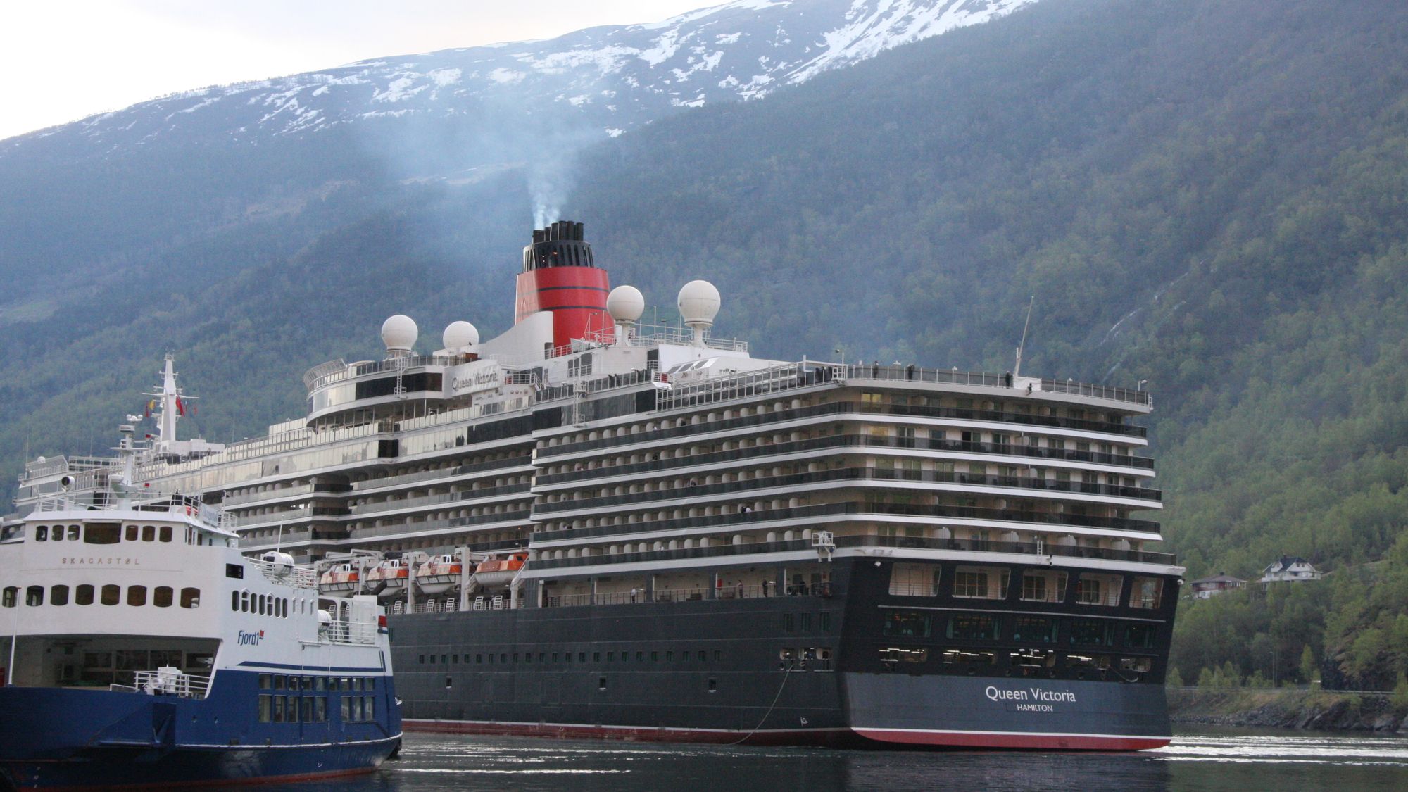 Queen Victoria på veg til kai i Flåm. Ein kan ikkje forventa at cruiseindustrien vil utvikla nullutsleppsteknologi dersom det kravet berre vert fastsett for 2-3 hamner i verdsarvfjordane, skriv ordføraren i Aurland.