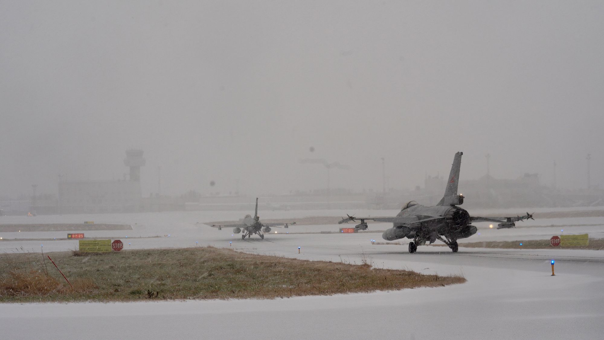 De to F-16 beredskapsflyene på vei ut fra shelterne på Bodø flystasjon.