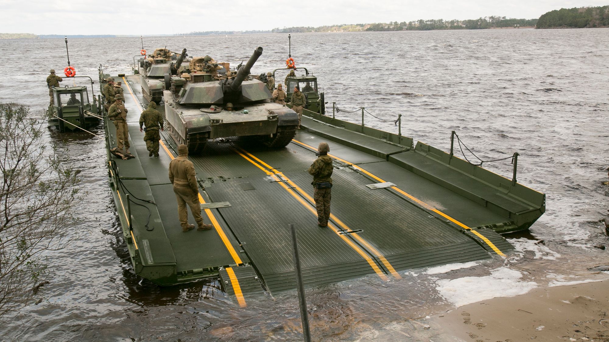 To M1A1 Abrams-stridsvogner i ferd med å fraktes over New River ved Camp Lejeune i Nord-Carolina.