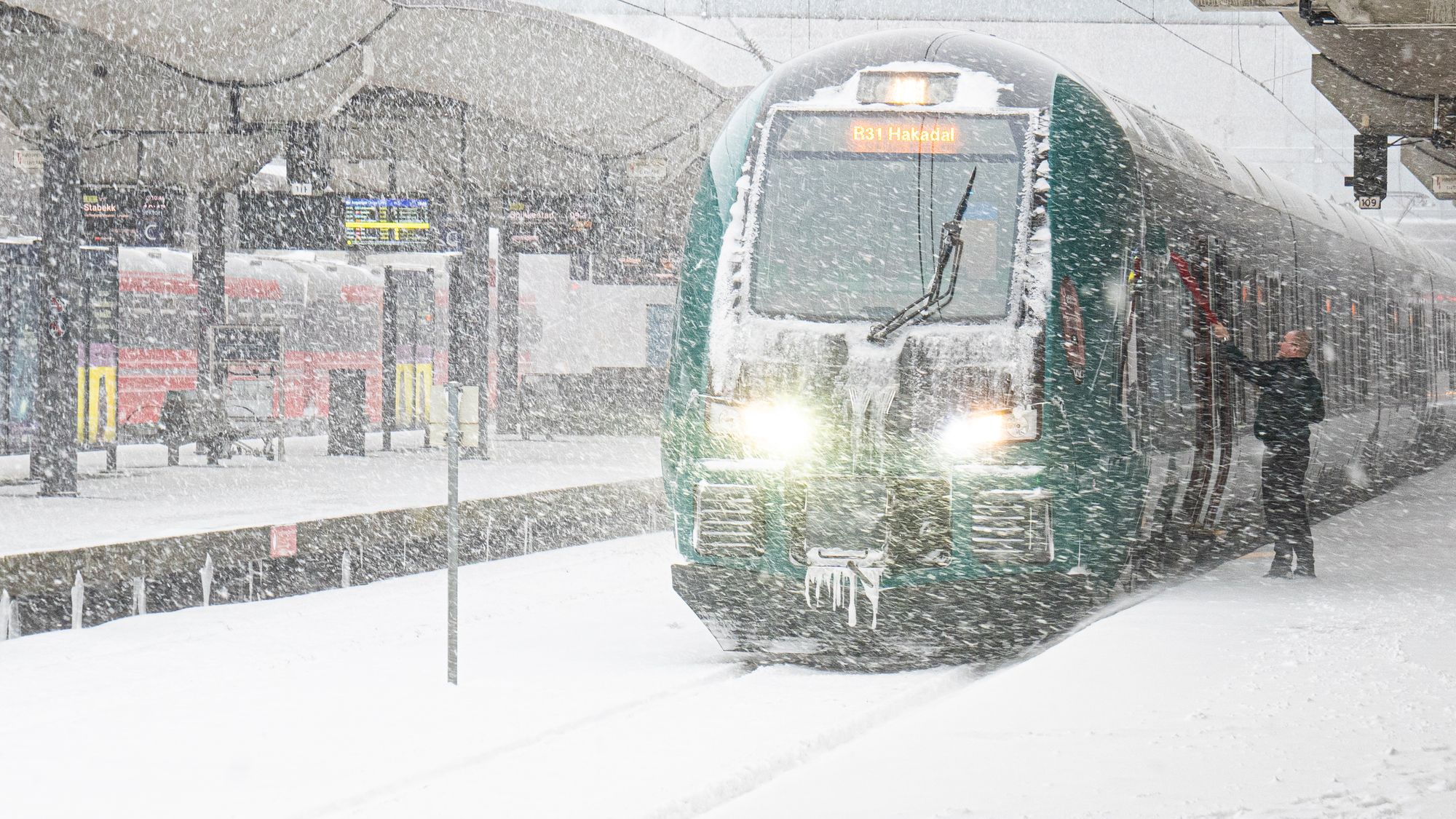 Togfører skraper is av toget før avgang fra Oslo S, 17. januar 2024. Kraftig snøfall på Østlandet skapte store utfordringer for togtrafikken forrige vinter.