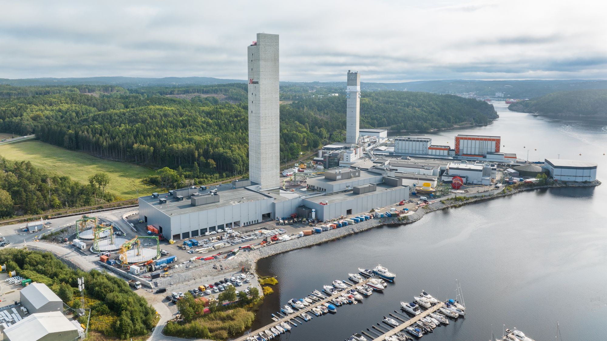 Nexans-tårnene, det nye nærmest, er landemerker i Halden og en viktig del av selve produksjonsflyten. På innsiden trekkes lederne til toppen, og på vei ned ekstruderes isolasjonslagene på. Tyngdekraften utnyttes for å produsere helt runde kabler, som kjøles og herdes på vei ned, før de fortsetter ferden i de andre produksjonslinjene på bakkenivå.