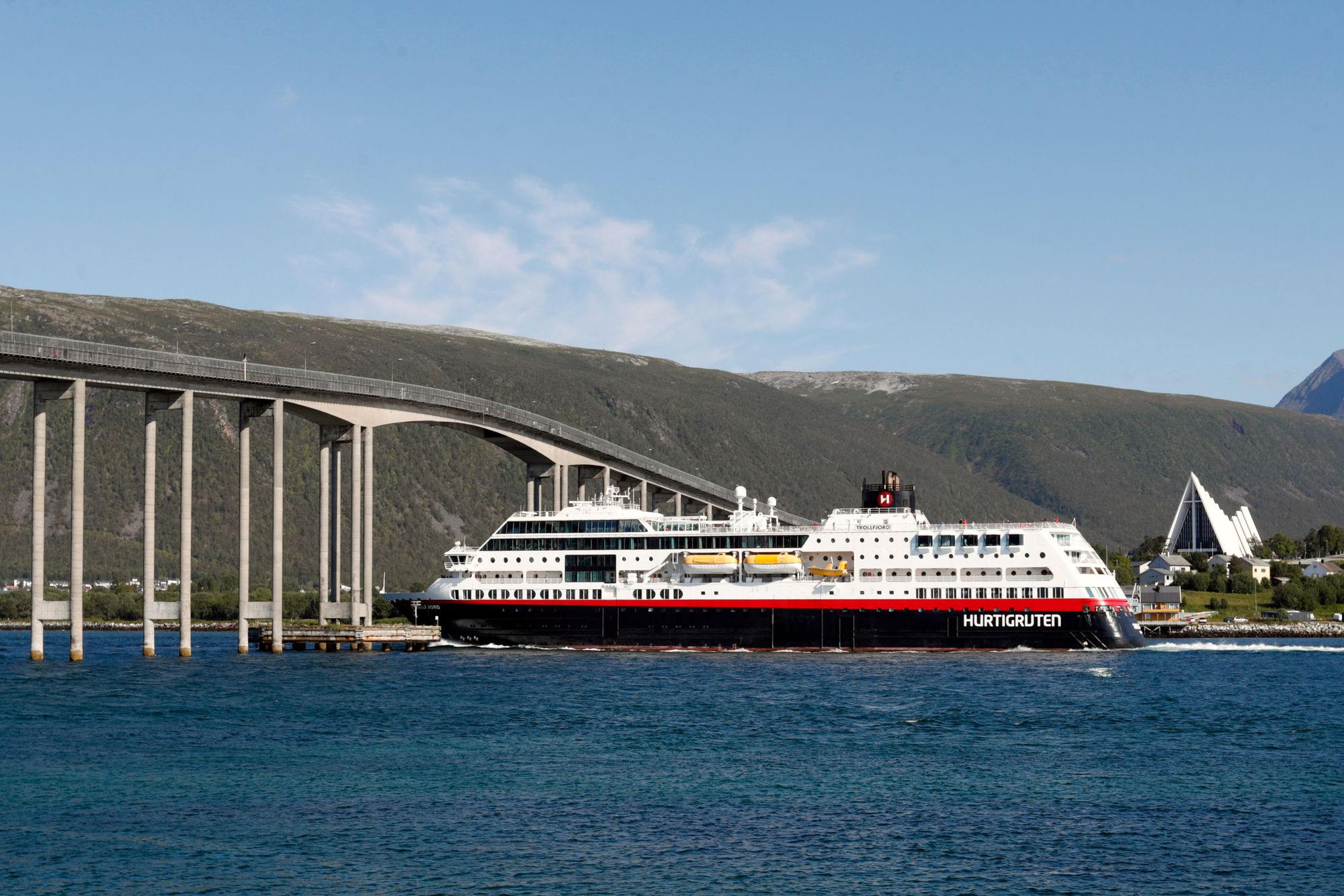 Hurtigruten Trollfjord under Tromsøbrua i sommer. Nå får selskapet nye eiere.