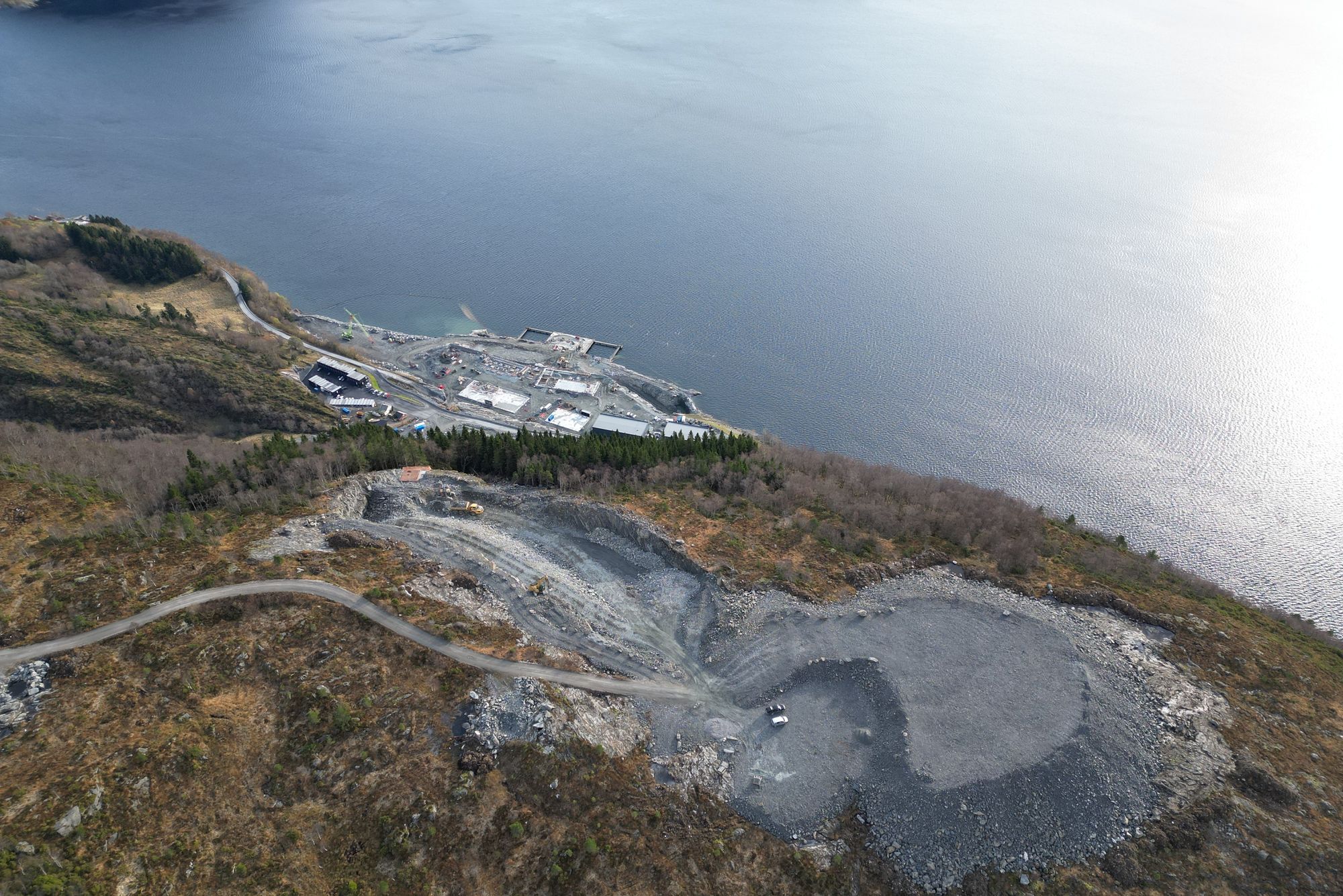 Bildet er fra forberedelsene til dagbruddet i Engebøfjellet i 2023. Nedenfor er Nordic Minings produksjonsanlegg.