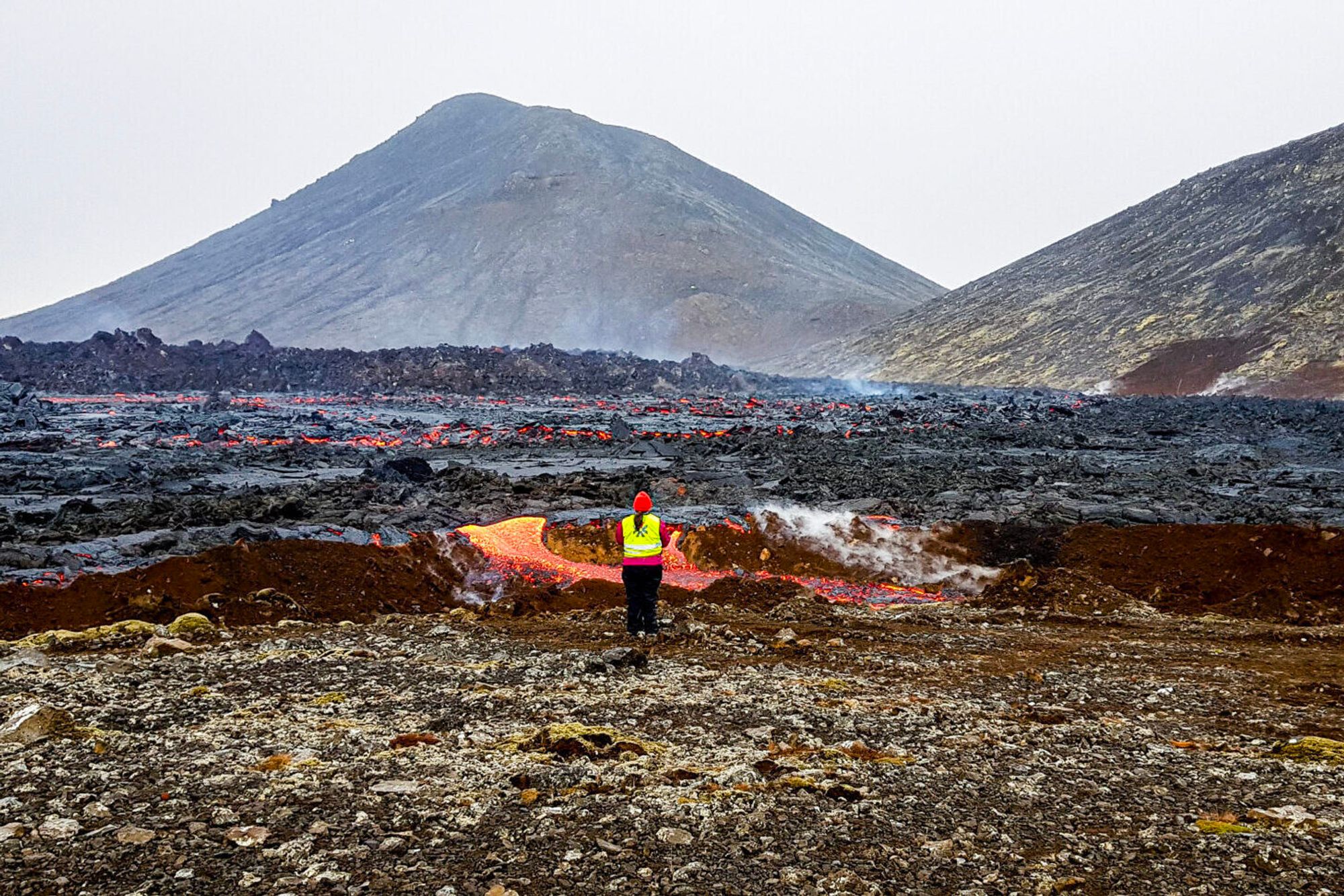 Vulkanen Fagradalsfjall var aktiv fra mars til september 2021. NTNU-professor Fjóla Guðrun Sigtryggsdóttir studerer lava som hadde begynt å strømme over en jordvoll nær en av demningene i det unike feltforsøket som startet i mai.